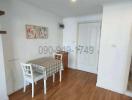 Compact dining room with wooden flooring and white walls