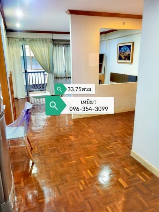 Spacious living room with parquet flooring leading to a balcony