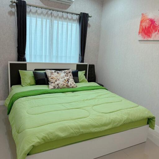 Bright and modern bedroom with neatly made bed and artistic wall decor