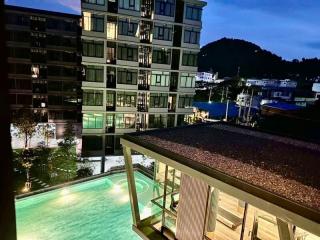 Modern apartment building exterior with pool view at twilight