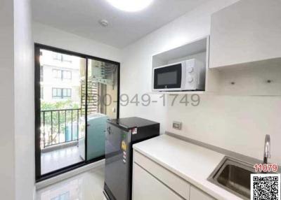 Compact modern kitchen with stainless steel appliances and balcony access
