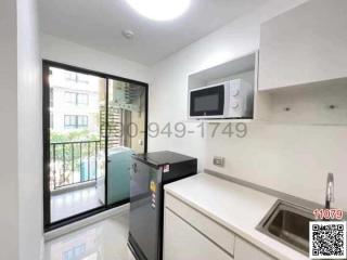 Compact modern kitchen with stainless steel appliances and balcony access