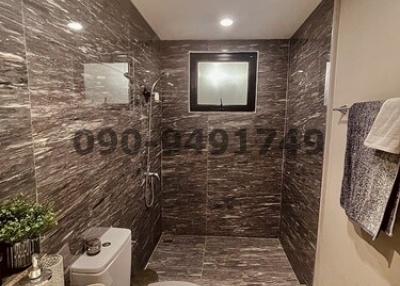 Modern bathroom with dark tiled walls and floor