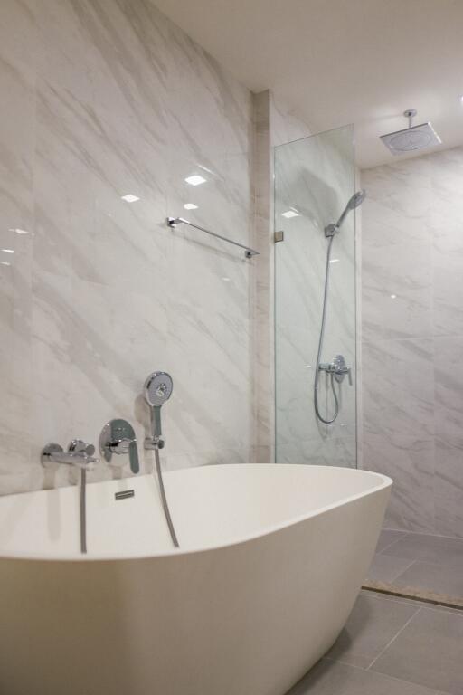 Modern bathroom interior with freestanding tub and glass shower enclosure