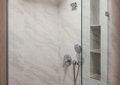 Modern bathroom with a glass shower and marble walls