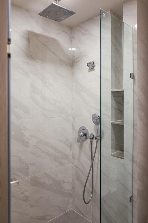 Modern bathroom with a glass shower and marble walls