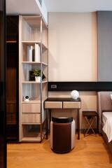 Modern bedroom with study corner featuring a desk, shelves, and a comfortable chair