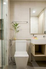 Modern bathroom interior with glass shower and wooden cupboard