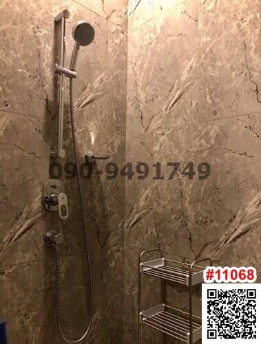 Modern bathroom with wall-mounted shower and marble tiles