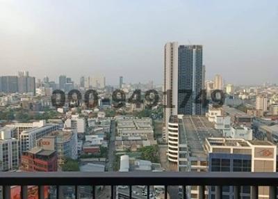 City view from high-rise balcony with visible railing and skyscrapers