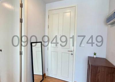 Entrance area with wooden floors, white walls, and a mounted air conditioning unit