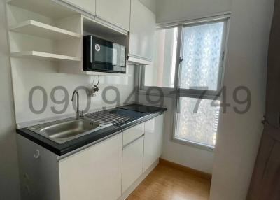 Compact modern kitchen with white cabinetry and wooden flooring