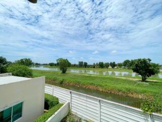 Spacious backyard with a view of a lake under a blue sky with clouds