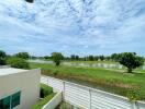 Spacious backyard with a view of a lake under a blue sky with clouds