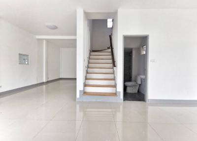 Spacious entrance hall with staircase and glossy tiled flooring