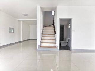 Spacious entrance hall with staircase and glossy tiled flooring