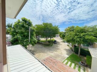 Expansive view from property balcony showing a residential area with clear skies and lush greenery