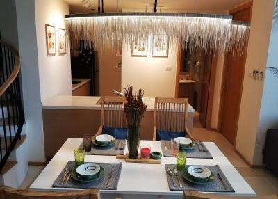 Modern dining area connected to the kitchen with elegant light fixture and open concept design