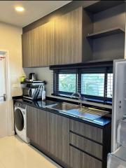 Compact modern kitchen with stainless steel appliances and wooden cabinetry