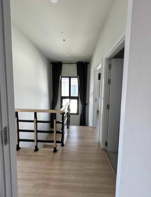 Spacious hallway in a modern home with hardwood floors and natural light