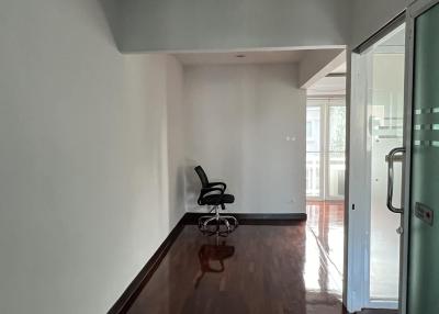 Empty interior space with hardwood floors and an office chair