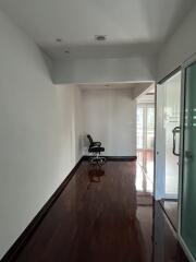 Empty interior space with hardwood floors and an office chair