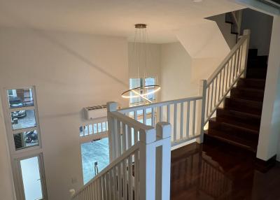 Spacious upstairs hallway with natural lighting and wooden flooring