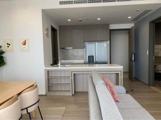 Modern kitchen with open plan living space, showing stainless steel appliances and cozy sitting area