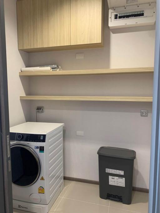 Compact laundry room with washing machine and storage shelves