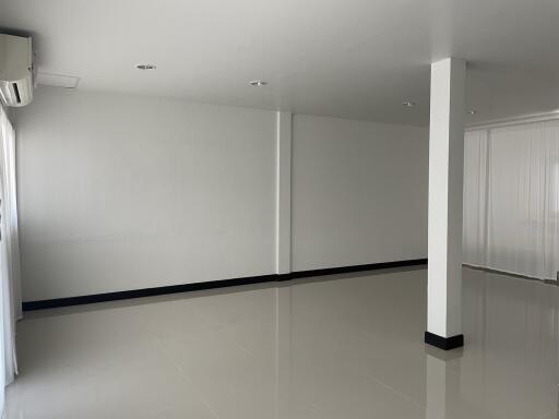 Spacious empty room with glossy floor and white walls