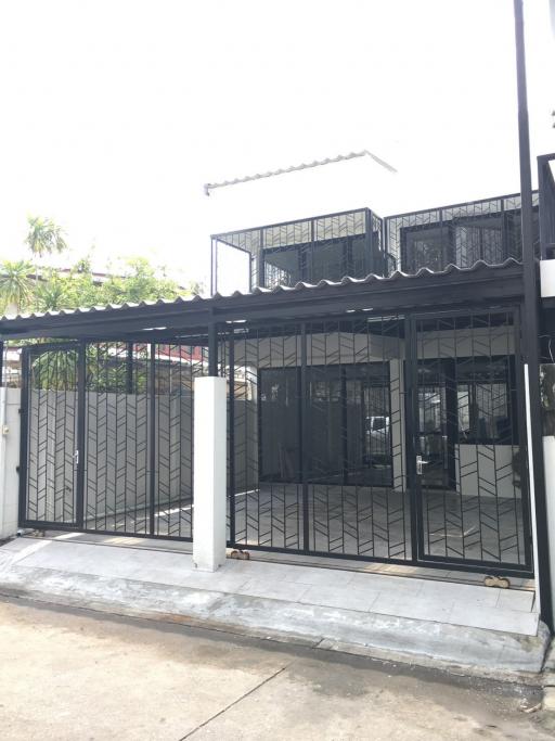 Modern two-story building with black gate and balcony