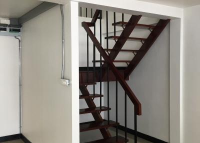Modern staircase with dark wooden steps and metal railings inside a well-lit space