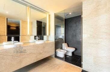 Modern bathroom with dual sinks and a glass-enclosed shower