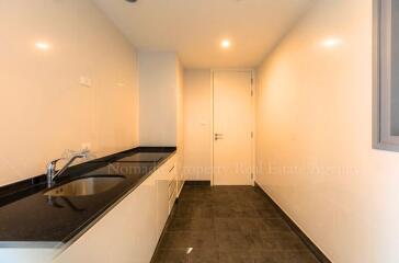 Narrow modern kitchen with tiled flooring and stone countertops