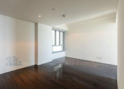 Spacious empty living room with hardwood floors and large window