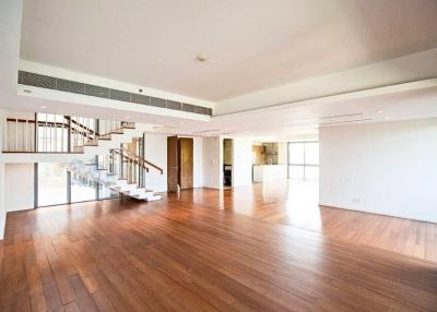 Spacious living room with wooden flooring and staircase leading to the upper level