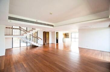 Spacious living room with wooden flooring and staircase leading to the upper level