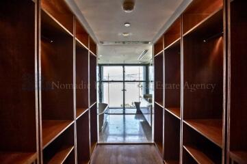 Spacious open corridor in building with shelving units and view to bright window