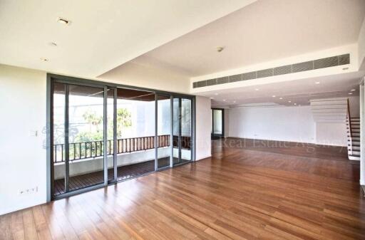 Spacious living room with hardwood floors and abundant natural light