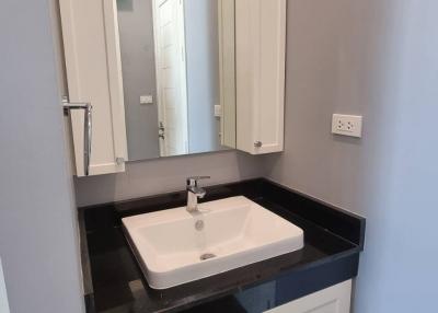 Compact modern bathroom with white cabinet and integrated sink