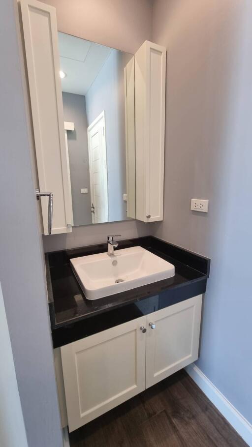 Compact modern bathroom with white cabinet and integrated sink