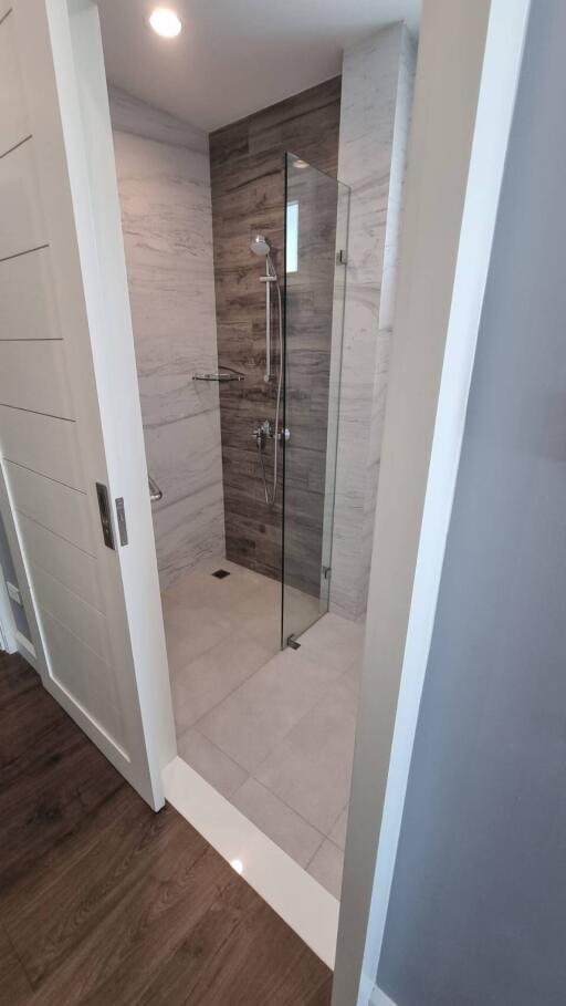 Modern bathroom with glass shower enclosure and marble walls