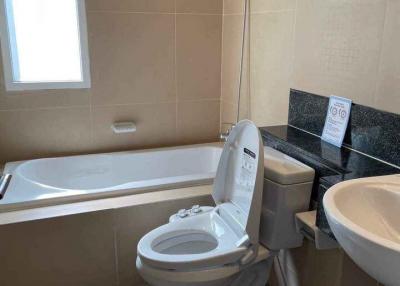 Modern bathroom with a toilet, bathtub, and sink