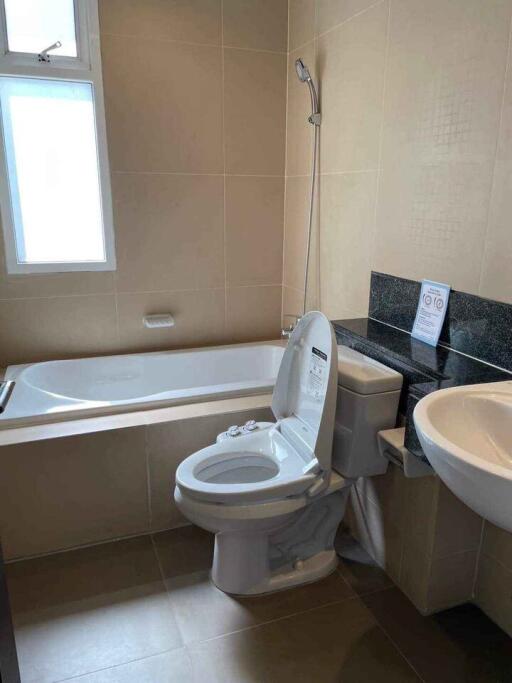 Modern bathroom with a toilet, bathtub, and sink