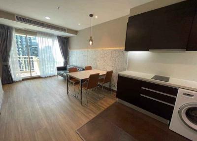 Modern kitchen with dining area, large windows, and integrated appliances