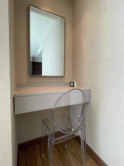 Cozy bedroom corner with a minimalist design featuring a transparent chair and a framed mirror