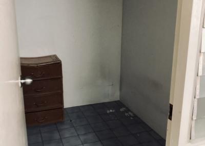 Empty small room with blue-tiled floor and an old wooden dresser