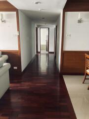 Spacious hallway leading to rooms with hardwood flooring