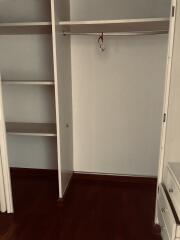 Empty bedroom closet with shelves and hanging rod