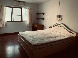 Spacious bedroom with a queen-sized bed and natural lighting